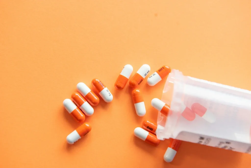 Prescription bottle with pills spilled on a table