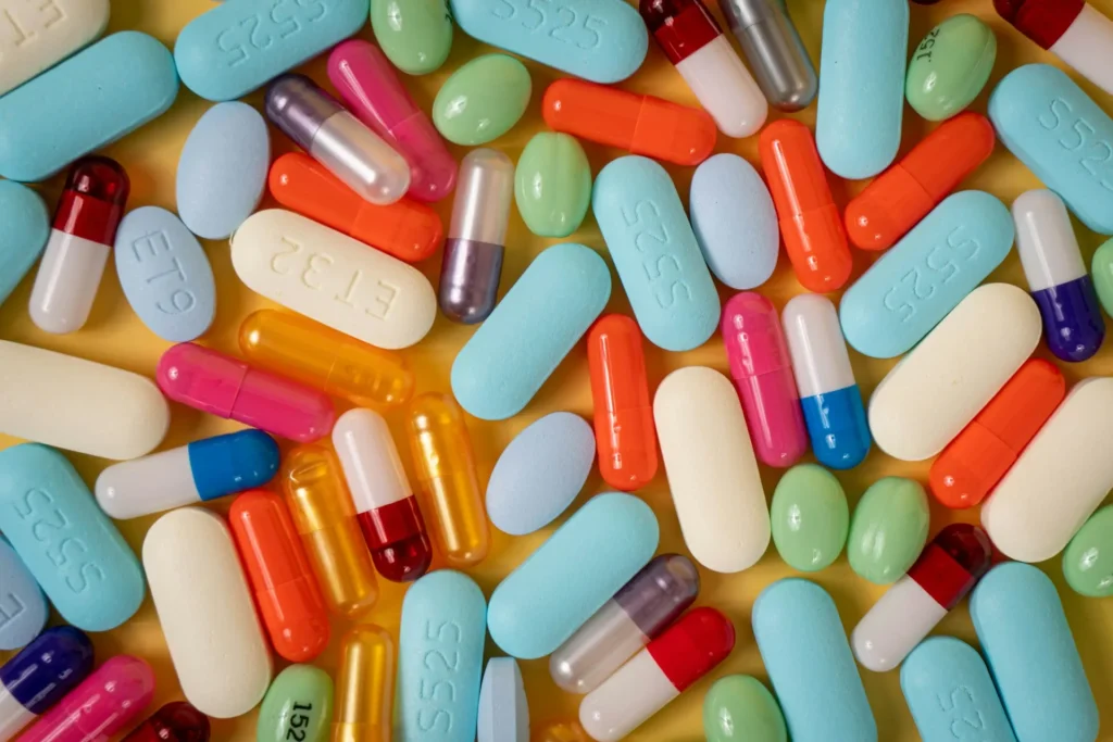 Colorful pills scattered on a table, representing the need for tracking pill containers and pill bottle trackers