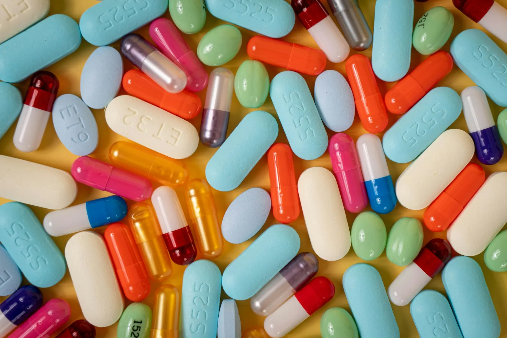 Colorful pills scattered on a table, representing the need for tracking pill containers and pill bottle trackers
